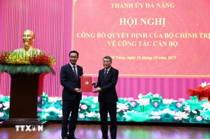 Товарищ Ле Минь Хынг, член Политбюро, секретарь ЦК КПВ, заведующий Отделом ЦК КПВ по организационной работе, вручает решение товарищу Ле Нгок Куангу. (Фото: ВИА)