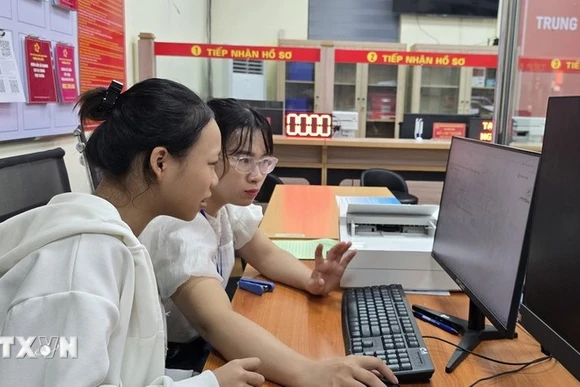 Госпожа Чан Тхи Ким Ньунг, специалист квартала Фулиен, Хайфон, помогает гражданам направлять документы для регистрации брака через Национальный портал государственных услуг. (Фото: ВИА)